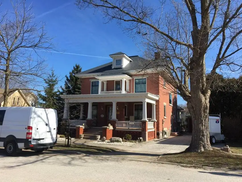 A large house with a van parked in front of it.