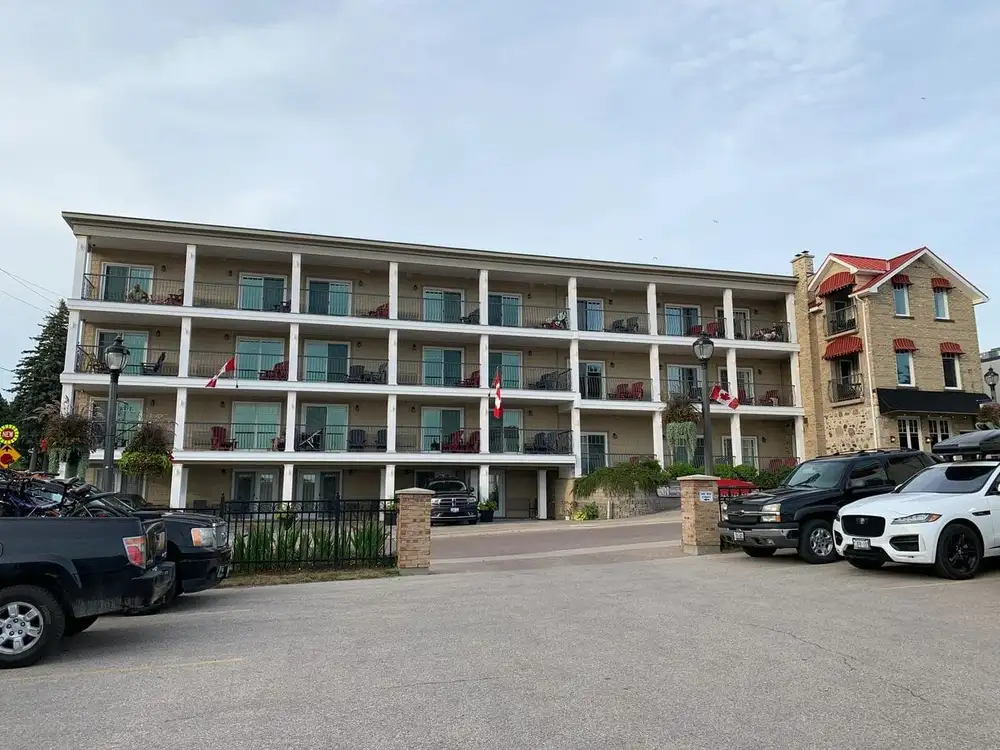 A hotel with cars parked in front of it.