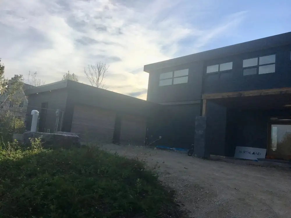 Dark modern two-story house with garage