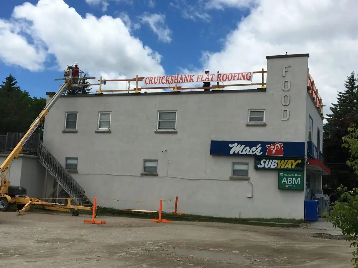 A Cruickshank crew member working on a large flat commercial roof